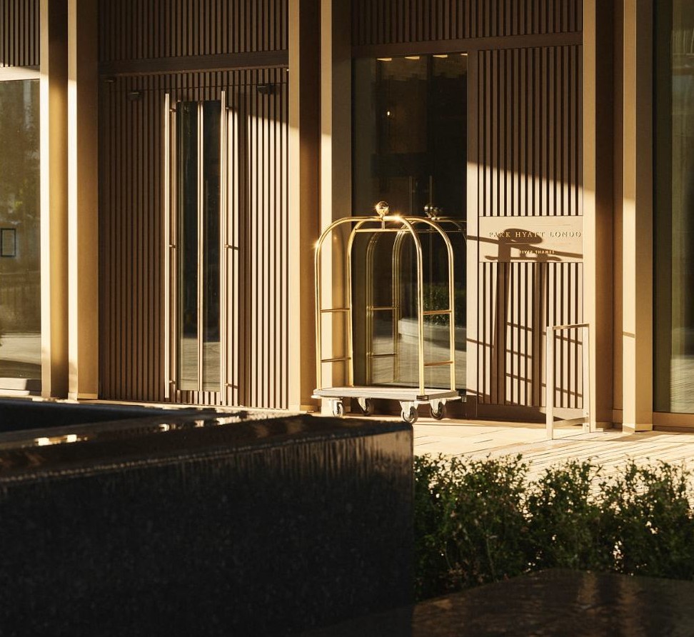 The residents' entrance at dusk, with a porter's trolley by the door